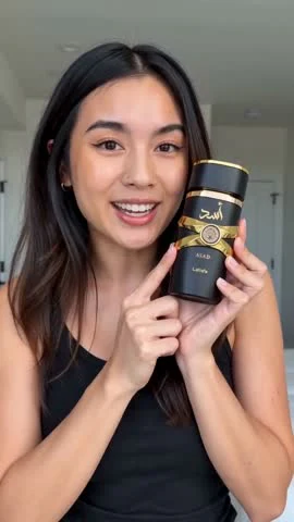 Moras AI video frame showing the presenter pointing to the fragrance bottle