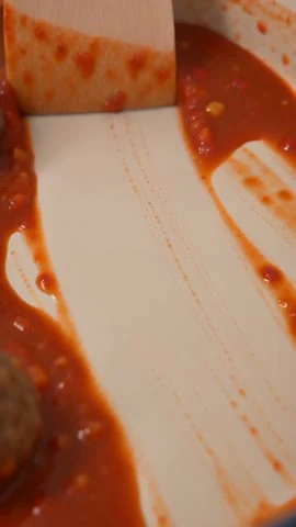 Moras AI video frame showing sauce and a utensil inside the cookware